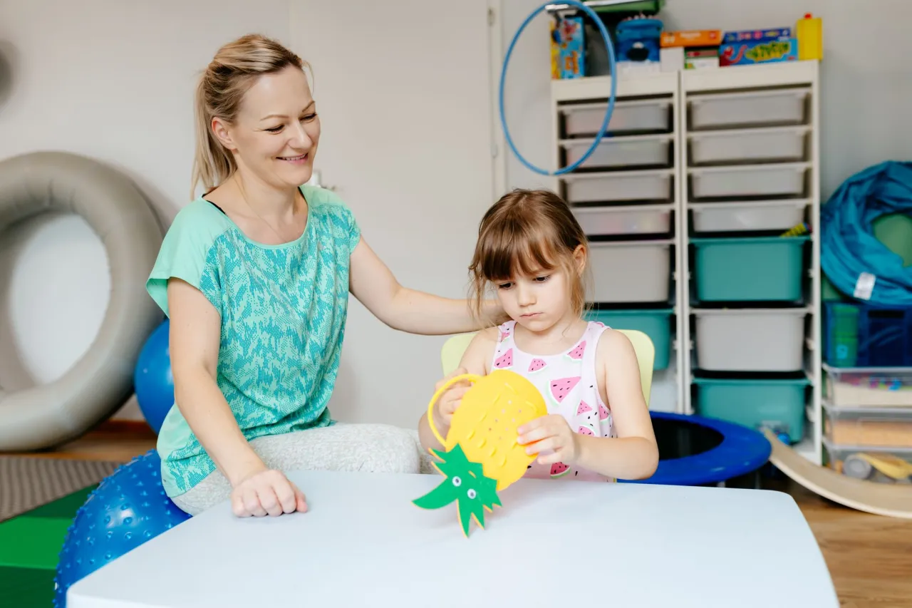 Dziecko bawi się z rodzicem, wykonując ćwiczenia sensoryczne w domu