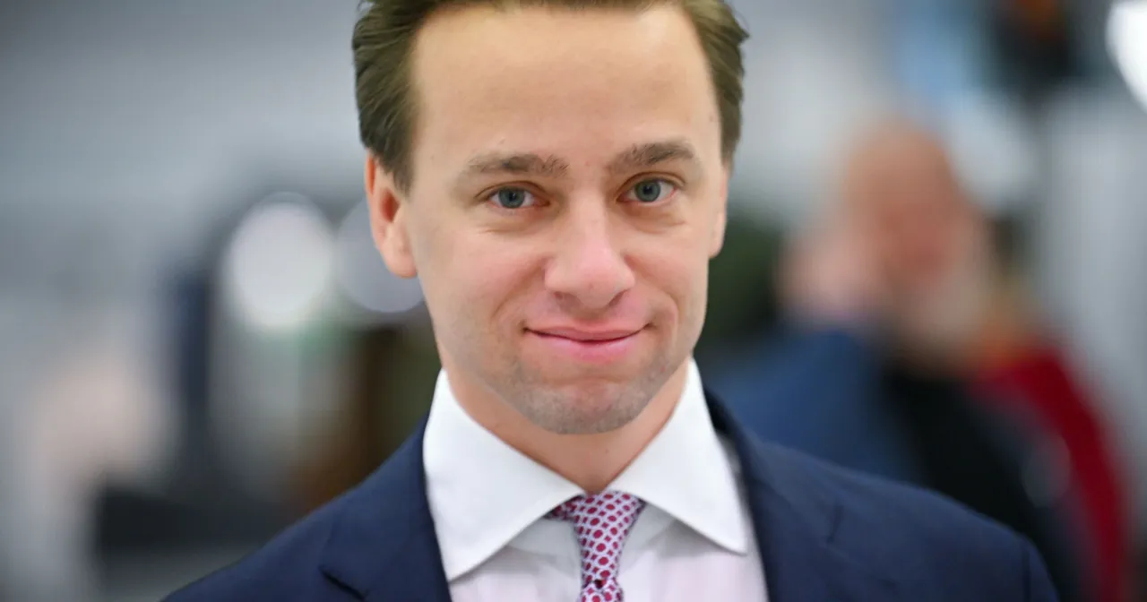 Uśmiechnięty mężczyzna w garniturze i krawacie. Trudno zgadnąć, ile lat ma Bosak, ale wygląda na młodego.