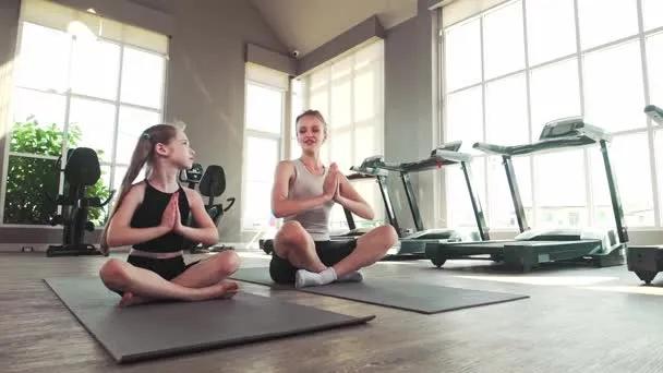 kobieta ćwicząca w domu na macie, str&oacute;j sportowy, jasne wnętrze