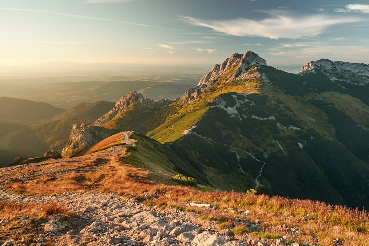 Słoneczny szlak na Giewont, wijący się przez skaliste grzbiety i zielone zbocza Tatr.
