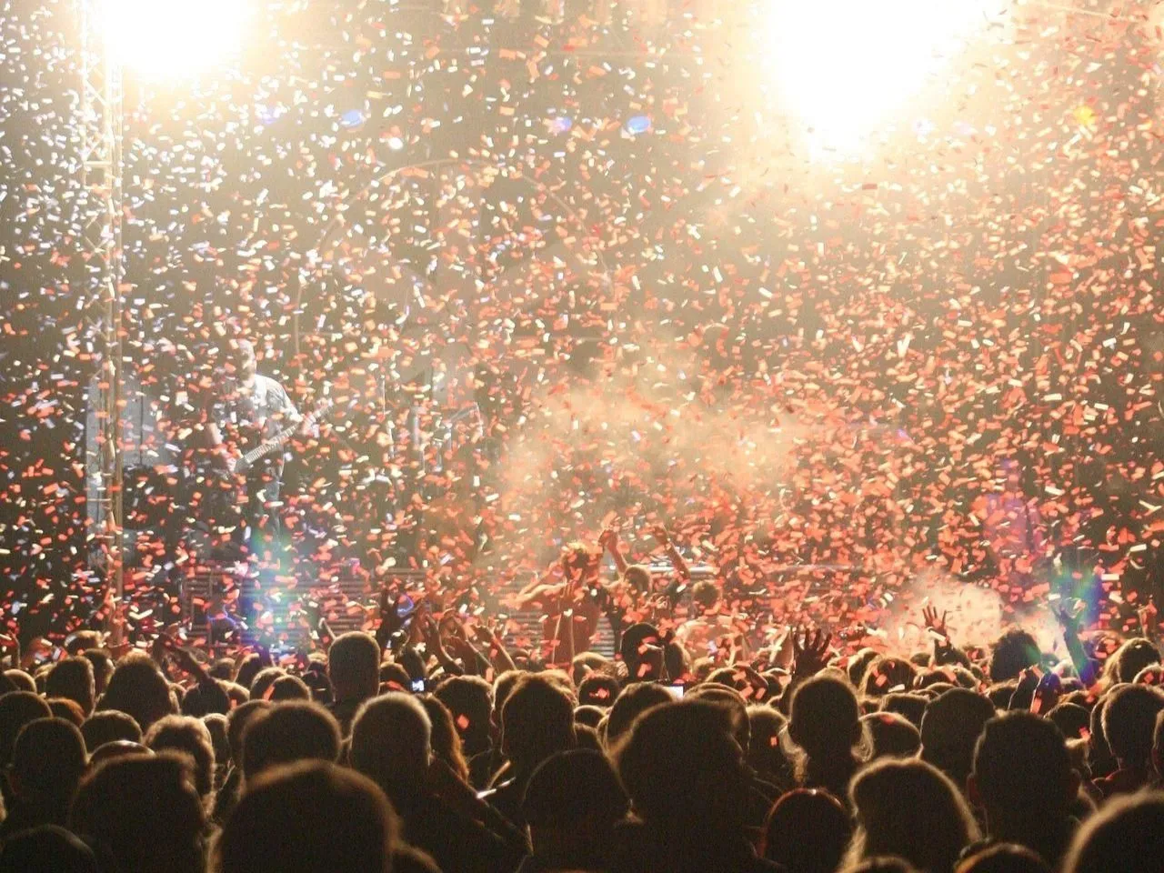 Konfetti spada na tłum podczas koncertu. W tle widać gitarzystę na scenie. To z pewnością niezapomniany sylwester w Białymstoku!