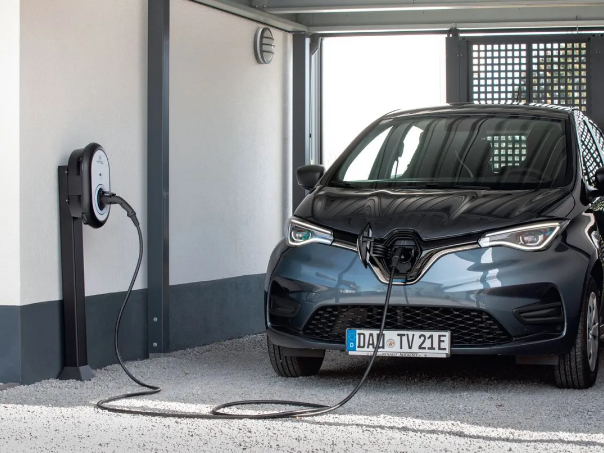 Szary samochód elektryczny podłączony do ładowarki. Czy ładowanie samochodu elektrycznego jest darmowe? Zależy od miejsca.