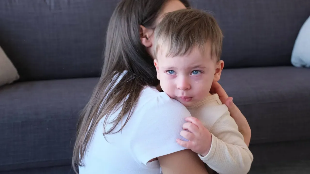 rodzic przytula płaczące dziecko