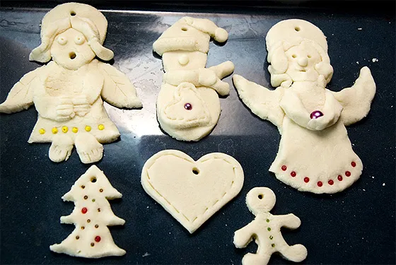 dziecko dekorujące figurki z masy solnej na Boże Narodzenie