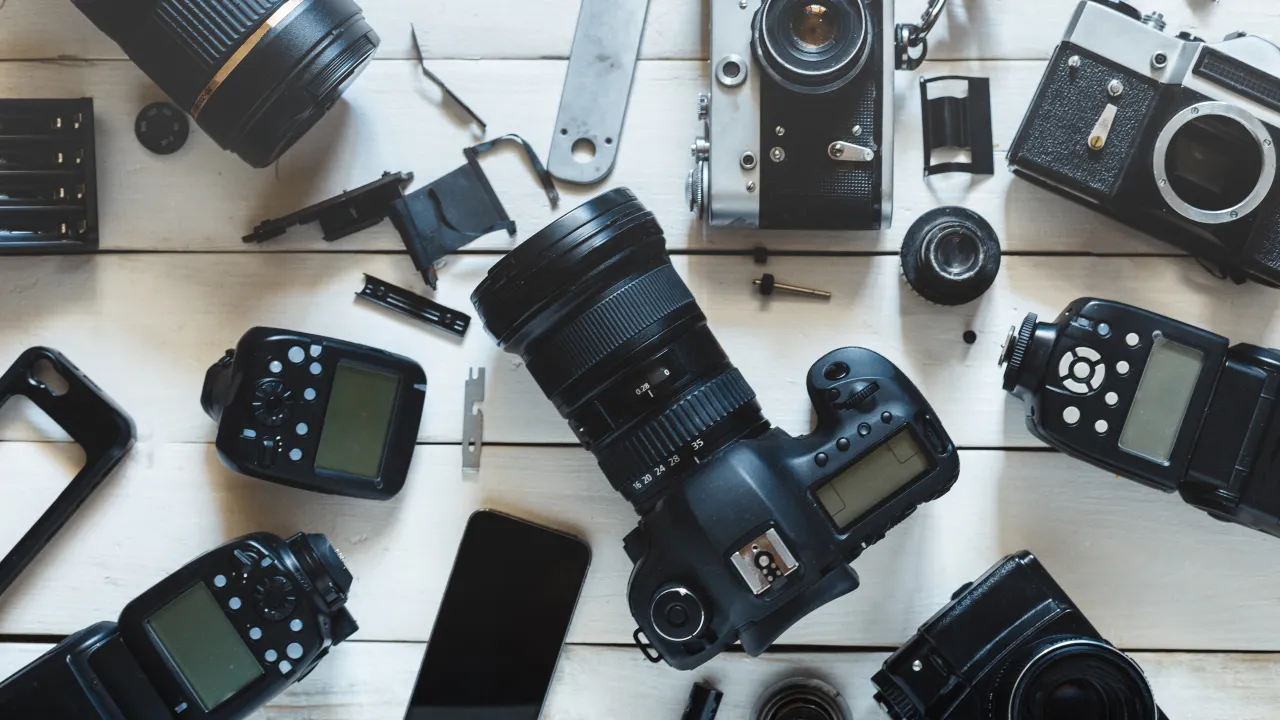 Zestaw sprzętu fotograficznego: lustrzanka, obiektywy, lampy błyskowe i akcesoria. Idealny do tworzenia rankingu aparat&oacute;w.