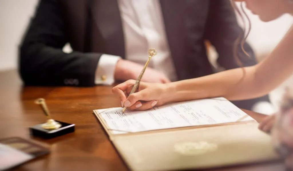 para młoda podpisująca dokumenty w urzędzie stanu cywilnego