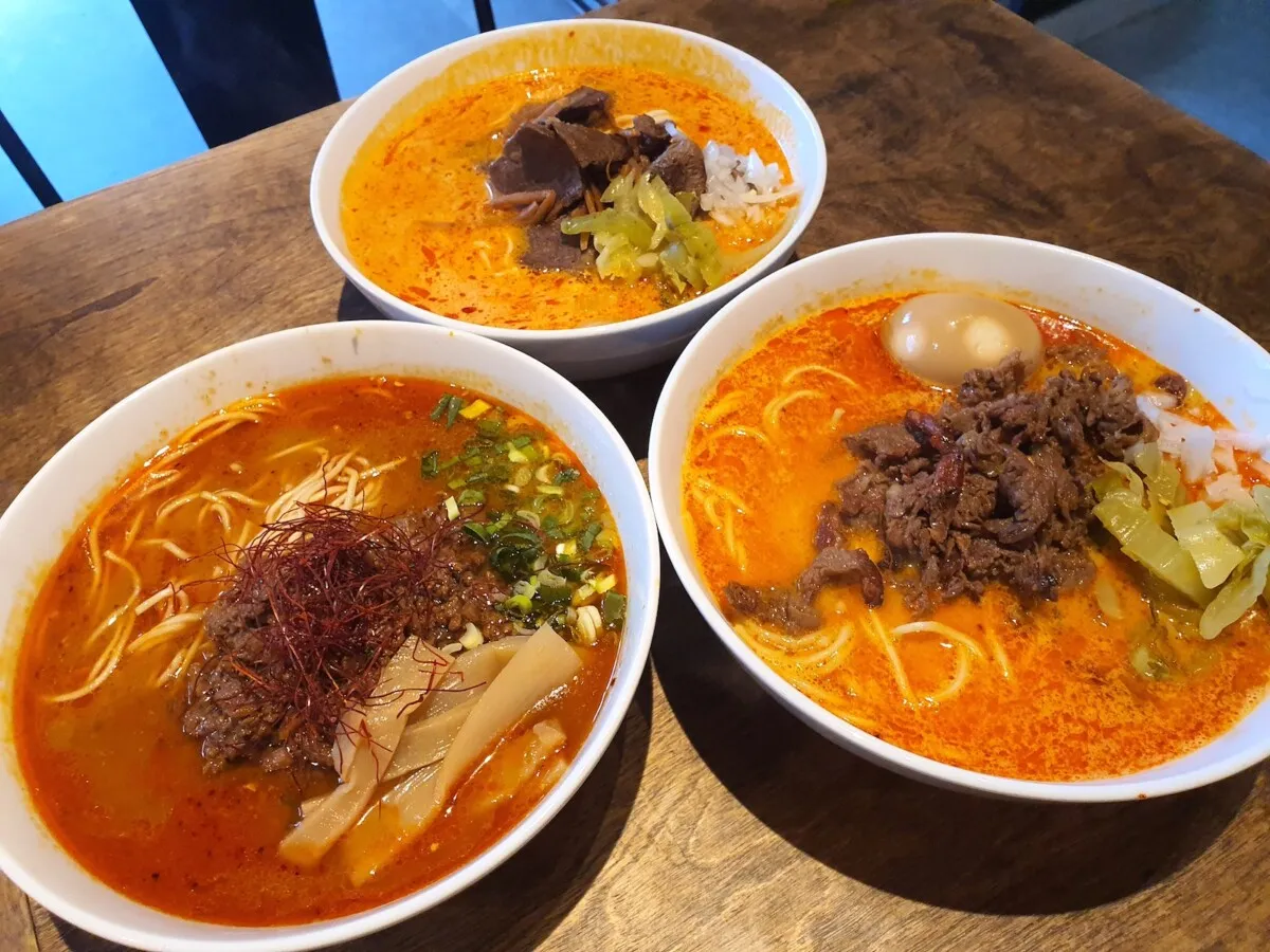 Trzy miski aromatycznego ramen z wołowiną w stylu bbq, jajkiem i warzywami.