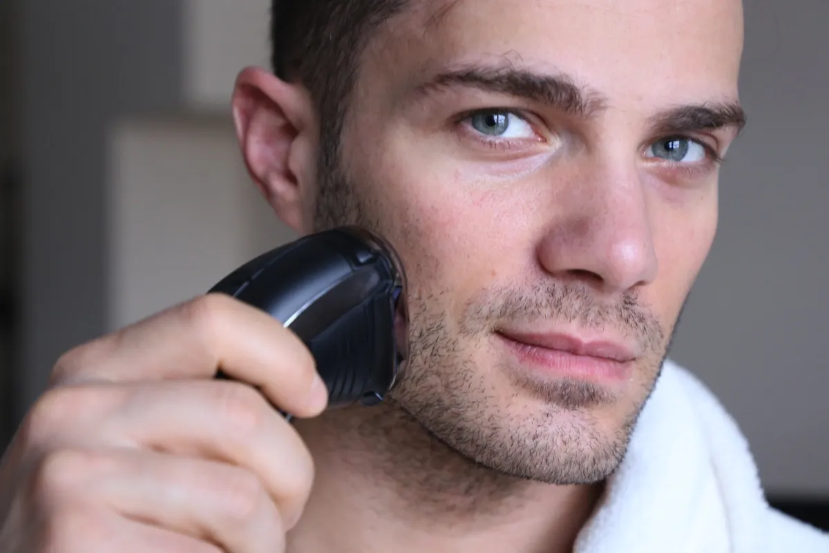 Mężczyzna sprawdzający swoją golarkę elektryczną