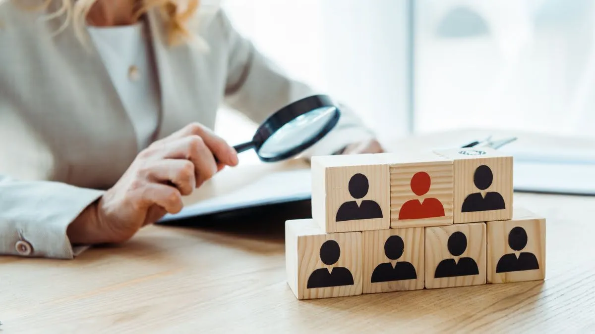 Osoba sprawdzająca dokumenty rekrutacyjne z lupą