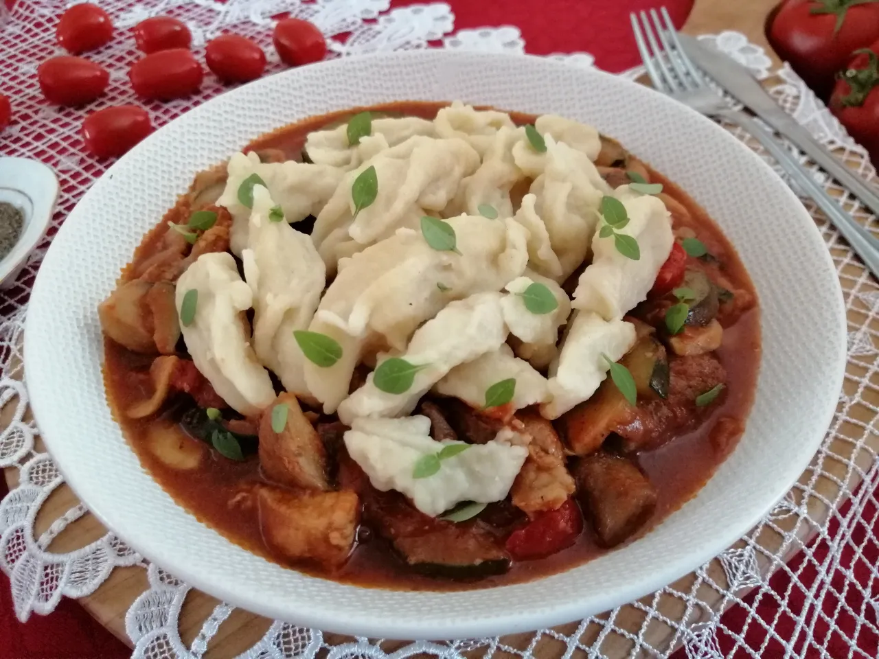 Kluski kładzione na talerzu z okrasą