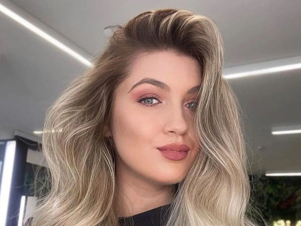 Kobieta z r&oacute;żową cerą i rumieńcami, ukazująca kontrast z kolorem włos&oacute;w