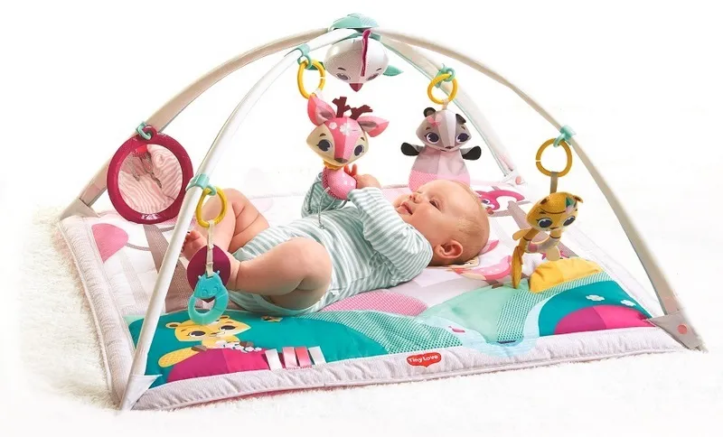 niemowlę na macie edukacyjnej z pałąkami