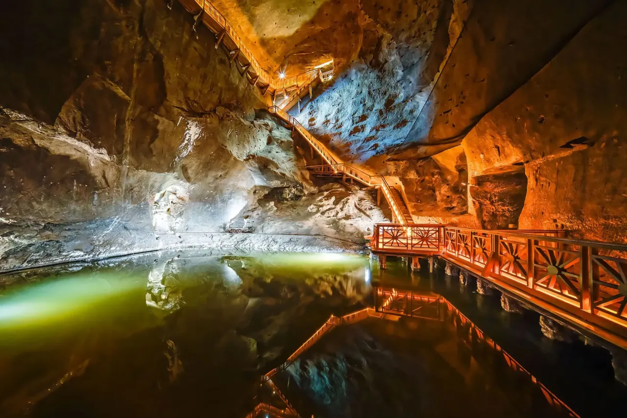 Podziemne jezioro w kopalni soli, oświetlone drewniane schody i balustrady. Jedno z 10 najpiękniejszych miejsc w Polsce.