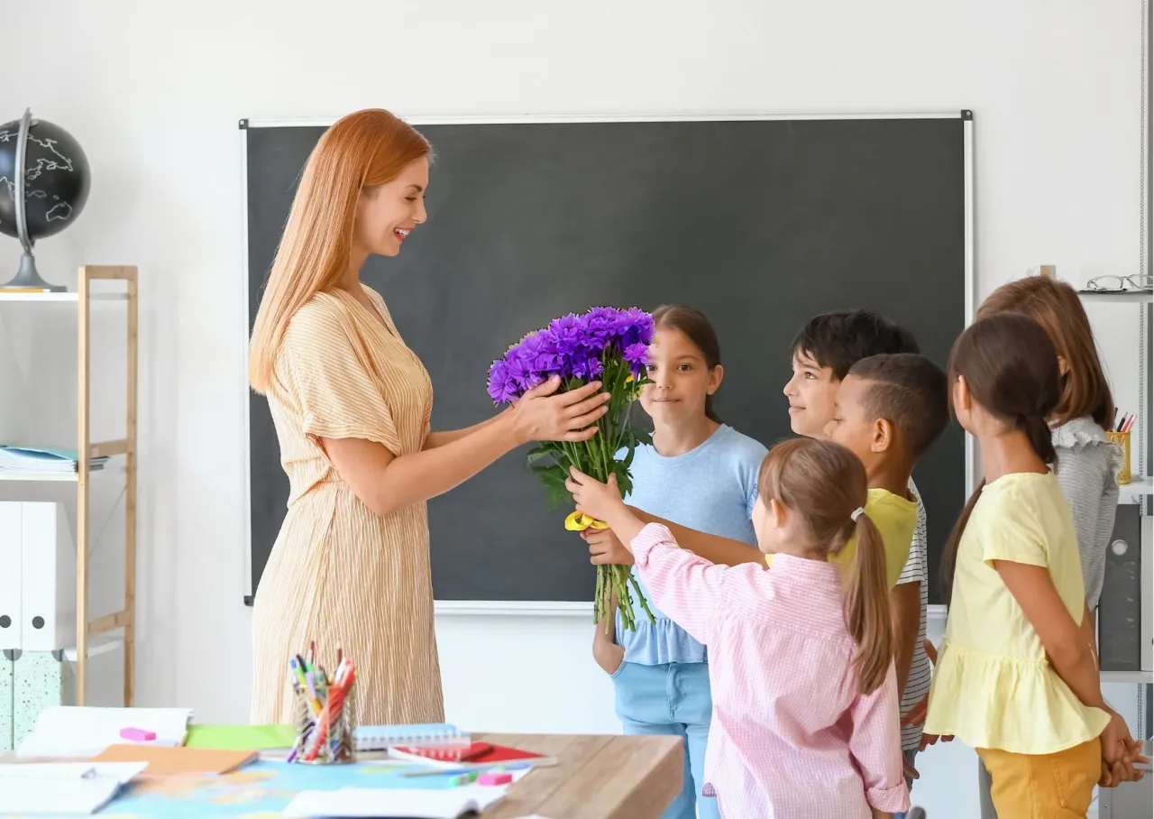 uczniowie wręczający prezent nauczycielowi