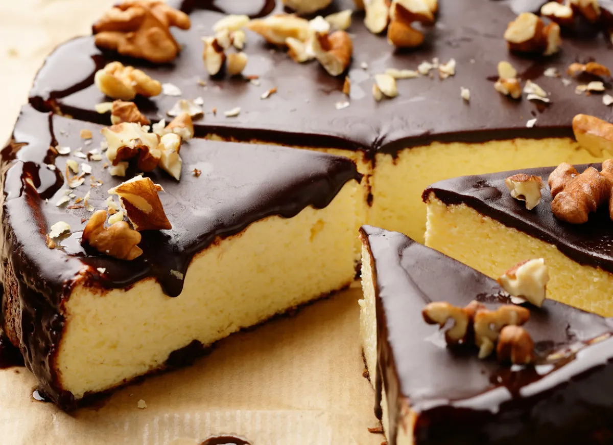 Sernik z polewą czekoladową i orzechami. Dowiedz się, jak uratować zwarzoną polewę czekoladową, by deser wyglądał idealnie.