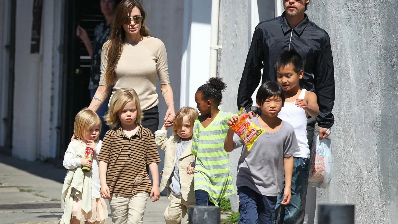 Angelina Jolie z dziećmi idzie ulicą. Widać ją z kilkorgiem dzieci, w tym z najmłodszymi, które trzyma za rękę.