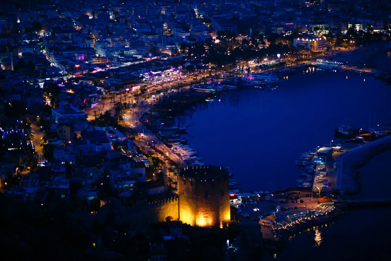 Nocna panorama Alanyi, Turcja. Oświetlony zamek i port pełen łodzi. Miasto tętni życiem, co sugeruje, że turcja alanya czy jest bezpiecznie - tak, wygląda na spokojne.