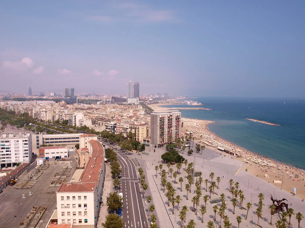 Plaża Barceloneta pełna ludzi i bar&oacute;w