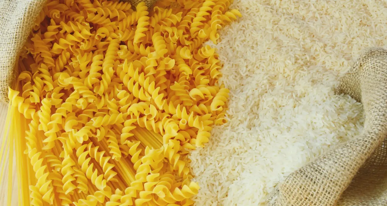 Biały ryż i makaron w workach z juty. Wybór między dwoma podstawowymi produktami spożywczymi.