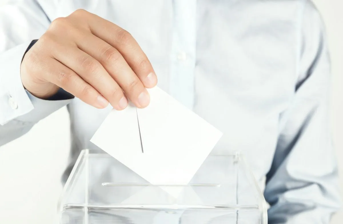 Osoba głosująca wrzucająca kartę do urny