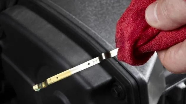 Motocyklista sprawdza poziom oleju silnikowego