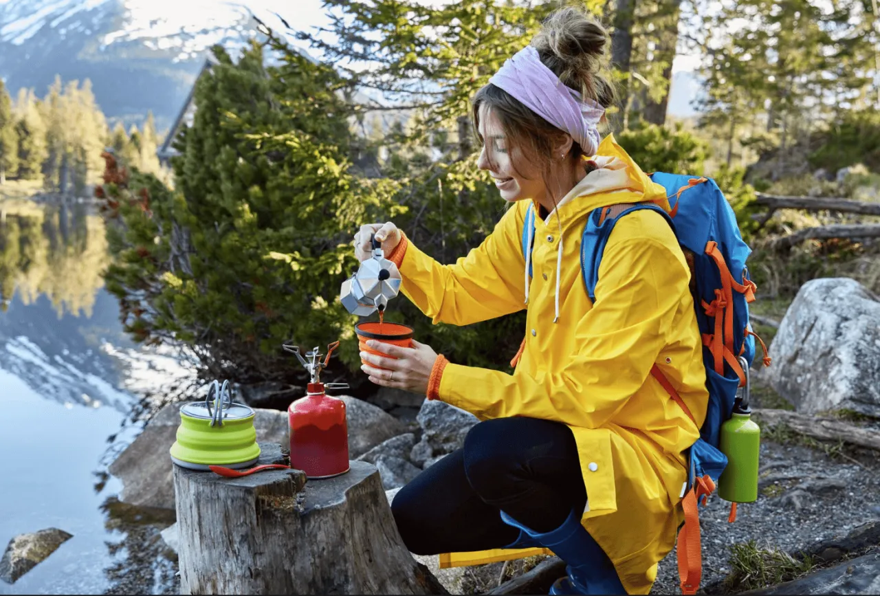 Woda i przekąski energetyczne w górach, turysta pijący wodę