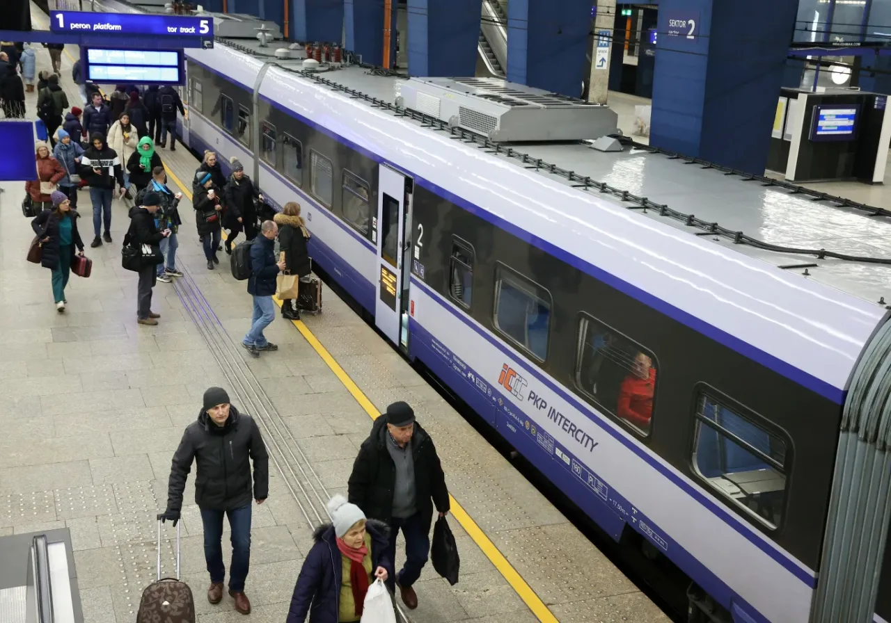 Ludzie na peronie PKP Intercity, niekt&oacute;rzy z bagażami. Zastanawiasz się, czy można zwr&oacute;cić bilet PKP?