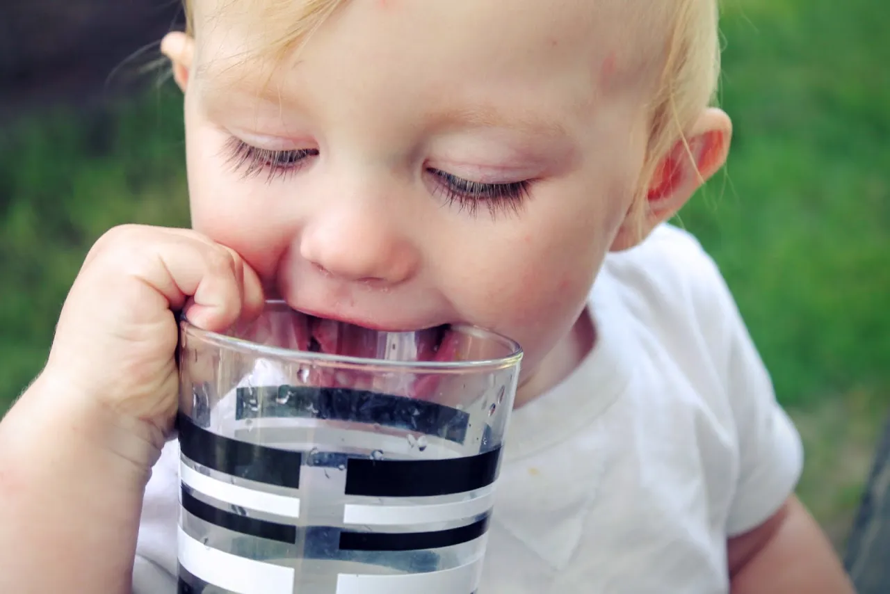Dziecko pije wodę w upał