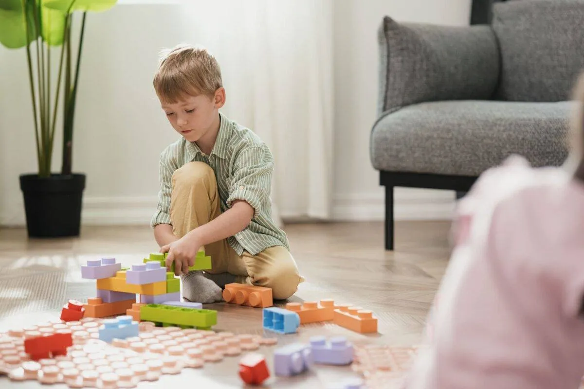 Dziecko z zespołem Aspergera rysujące, uśmiechnięte