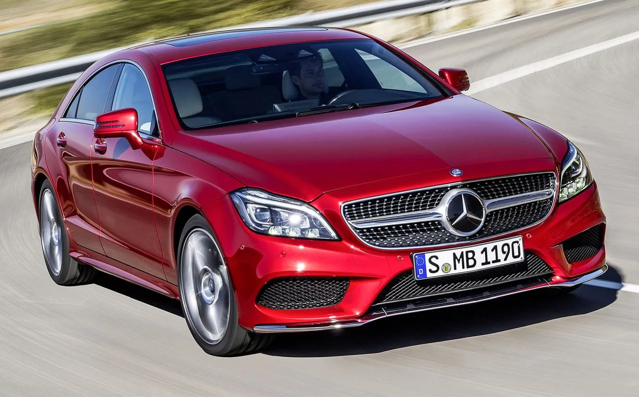 Czerwony Mercedes-Benz CLS 63 AMG pędzi po drodze, kierowca skupiony na trasie.