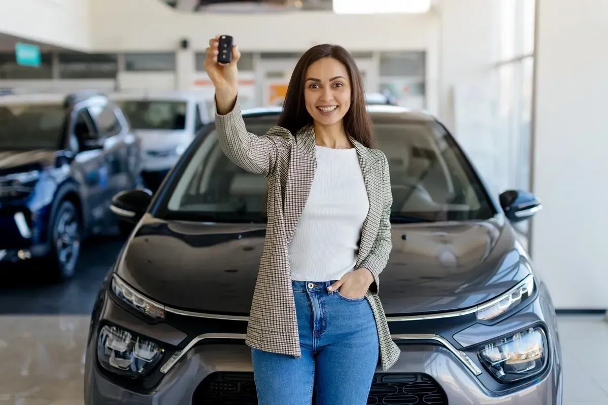 Kobieta z kluczykami do nowego auta, kt&oacute;re właśnie kupiła. Chcesz wiedzieć, jak sprawdzić czy auto jest w leasingu?