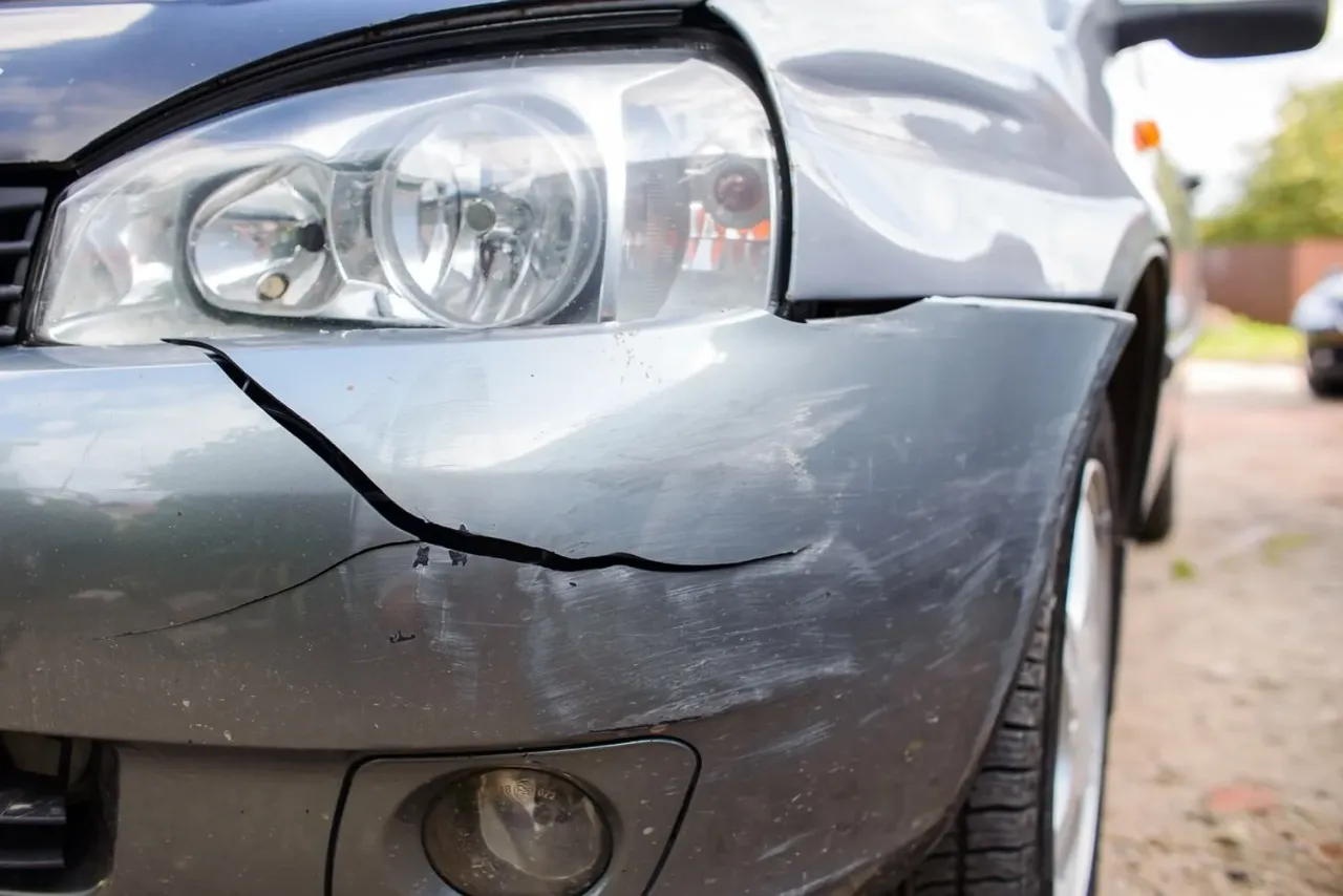 Pęknięty plastikowy zderzak samochodu, pokazujący jak naprawić go domowym sposobem.