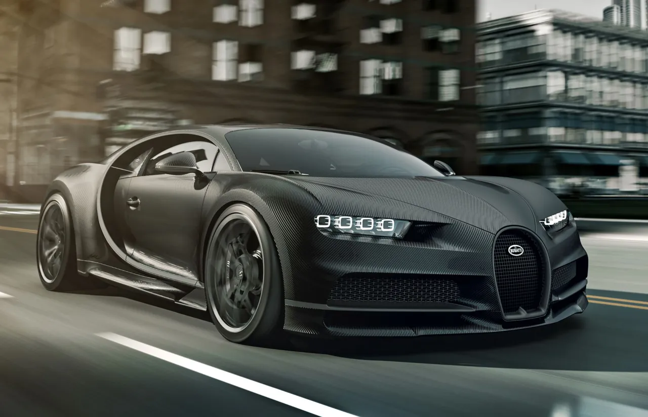 Czarny Bugatti Chiron z włókna węglowego pędzi przez miasto. Zastanawiasz się, ile kosztuje Bugatti?