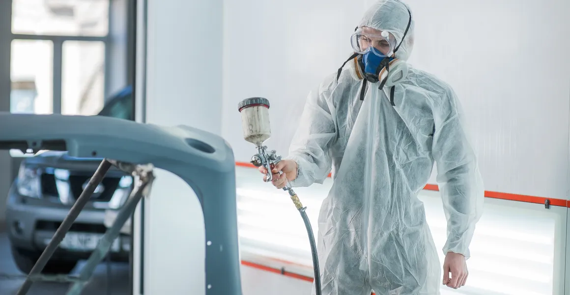 Lakiernik samochodowy przygotowujący farbę i narzędzia