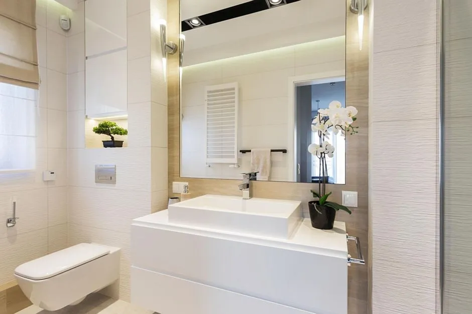 Jasna łazienka z dużym lustrem i wielopunktowym oświetleniem