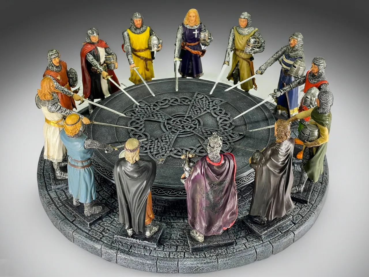 Figurki rycerzy Okrągłego Stołu, symbolizujące legendę o kr&oacute;lu Arturze, stoją wok&oacute;ł kamiennej platformy z celtyckim wzorem.