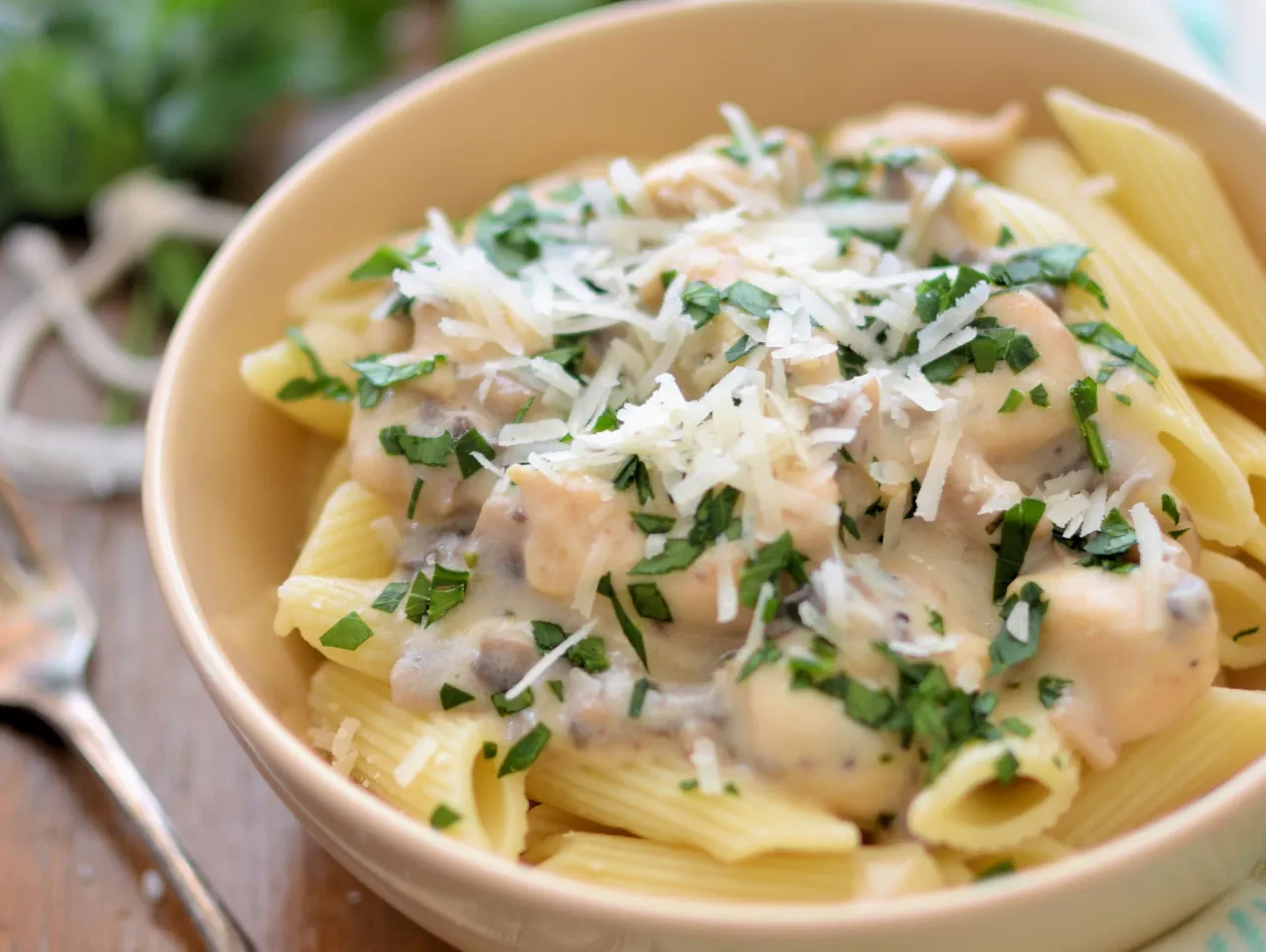 Penne z kremowym sosem pieczarkowym, posypane parmezanem i natką pietruszki. Idealne danie, które pasuje do sosu pieczarkowego.