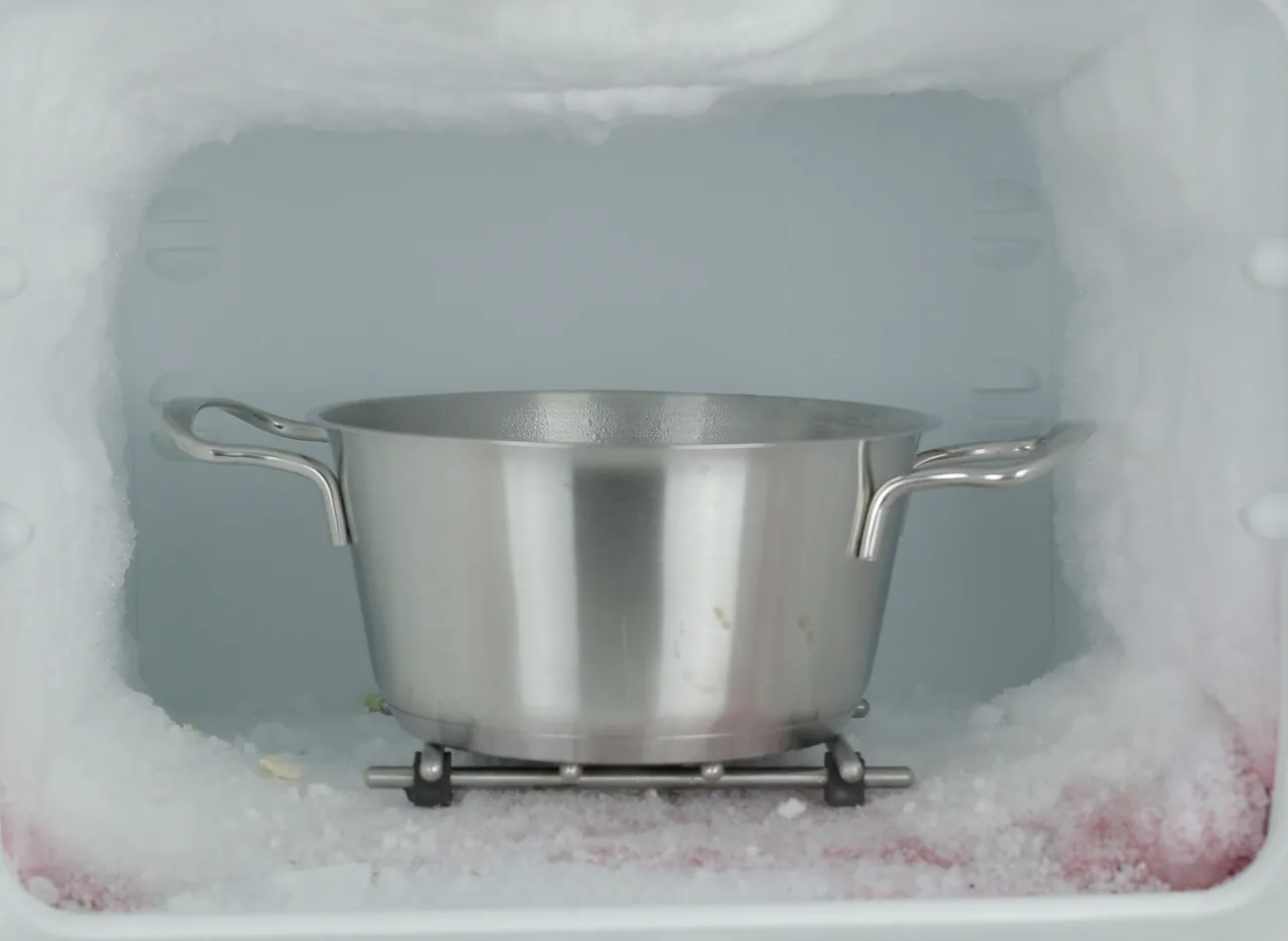 garnek z gorącą wodą w zamrażalniku