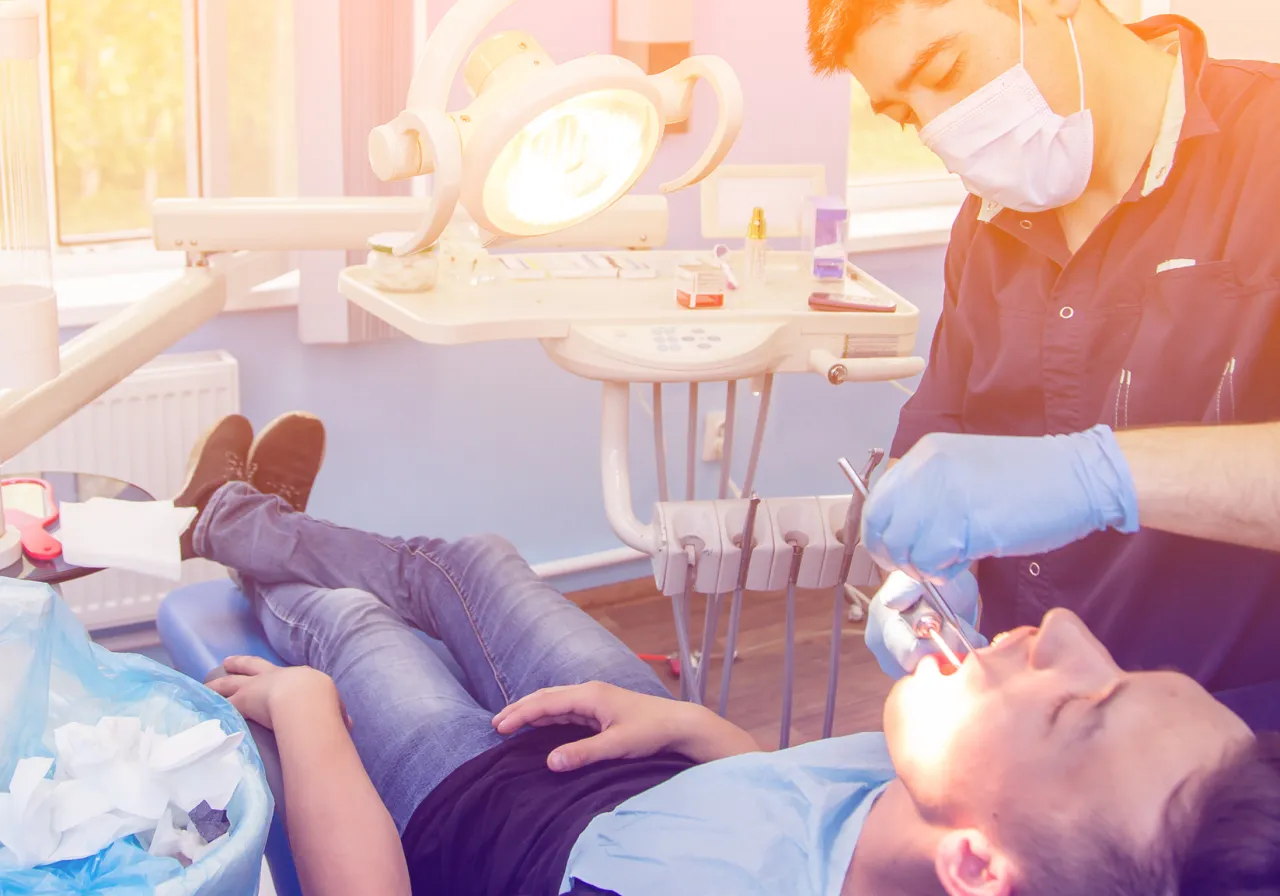 stomatolog zdejmujący szwy z dziąsła