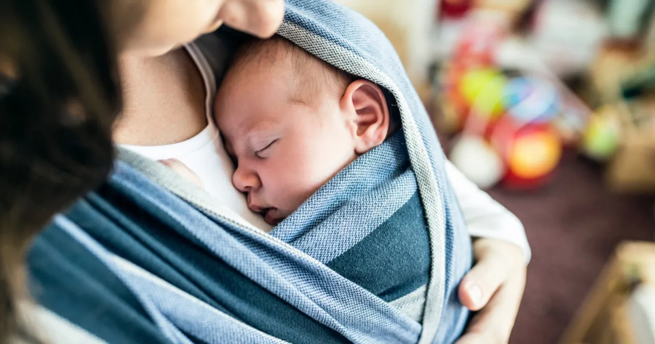 rodzic noszący niemowlę w chuście