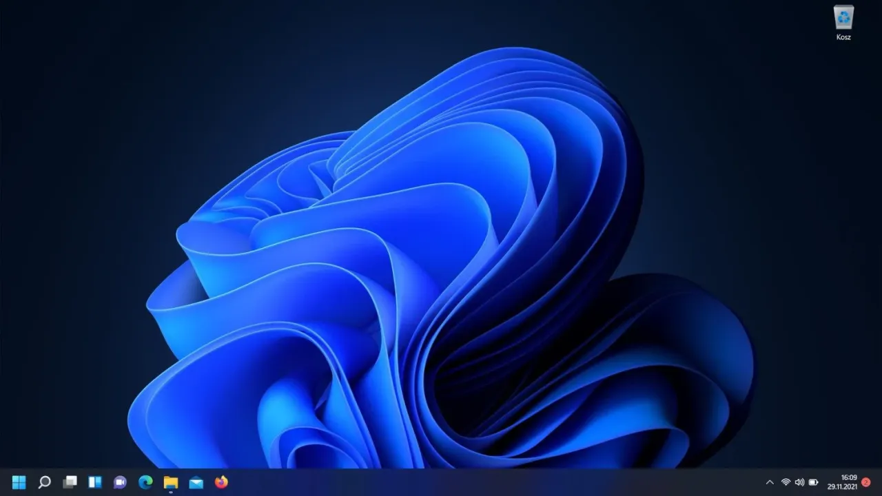 Widok pulpitu Windows 11 z niebieską, abstrakcyjną tapetą. Dowiedz się, jak zmienić tapetę na laptopie, aby spersonalizować swój komputer.