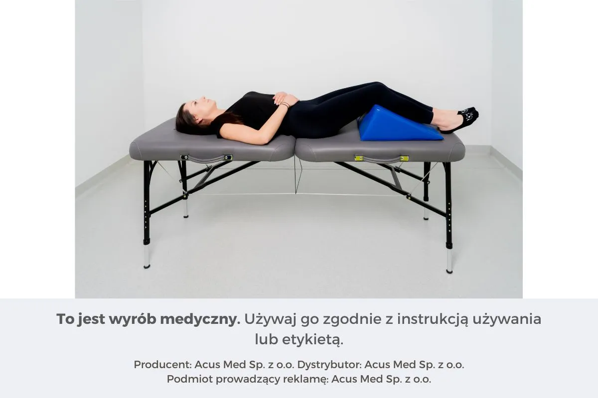 Kobieta leży na kozetce z nogami opartymi na niebieskim klinie. To jest klin medyczny.