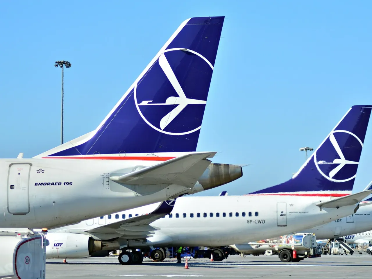 Dwa samoloty LOT-u na płycie lotniska. Zastanawiasz się, ile trwa lot z Polski do Jordanii?