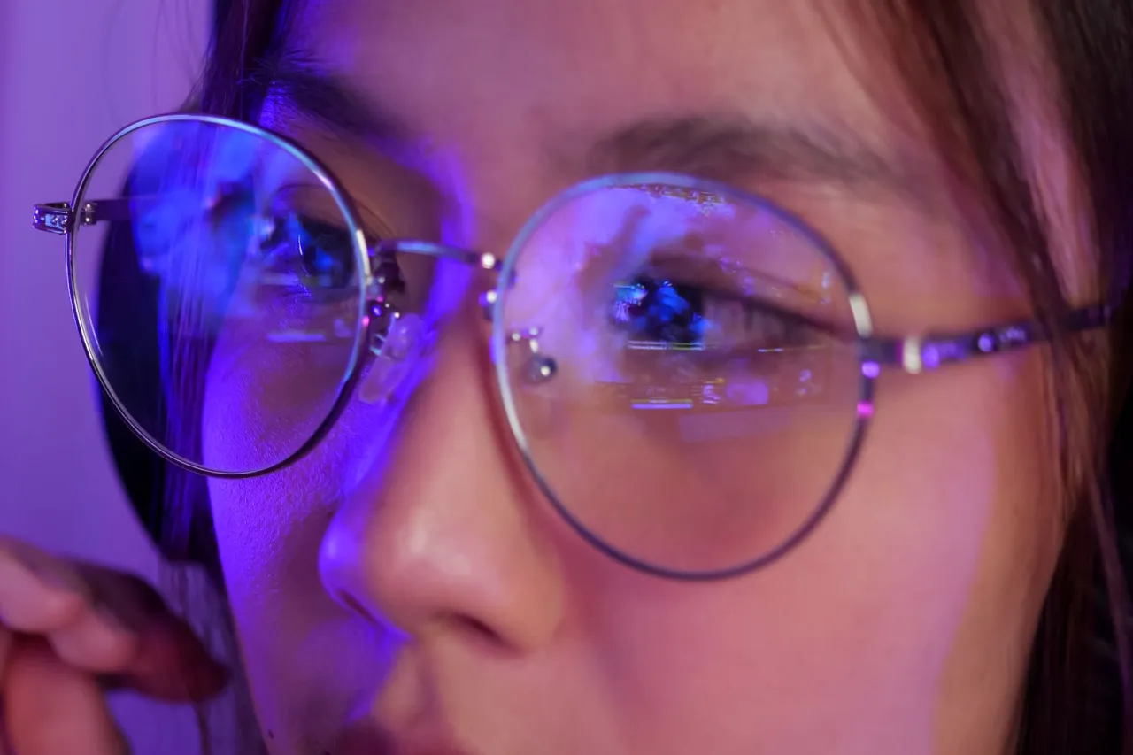 osoba w okularach z filtrem światła niebieskiego przy komputerze