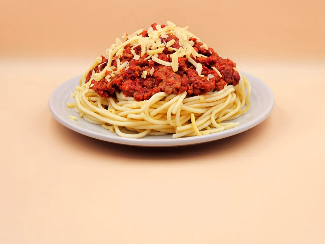 Porcja spaghetti z sosem bolońskim i startym serem. Zastanawiasz się, ile kalorii ma sos do spaghetti z mięsem mielonym?