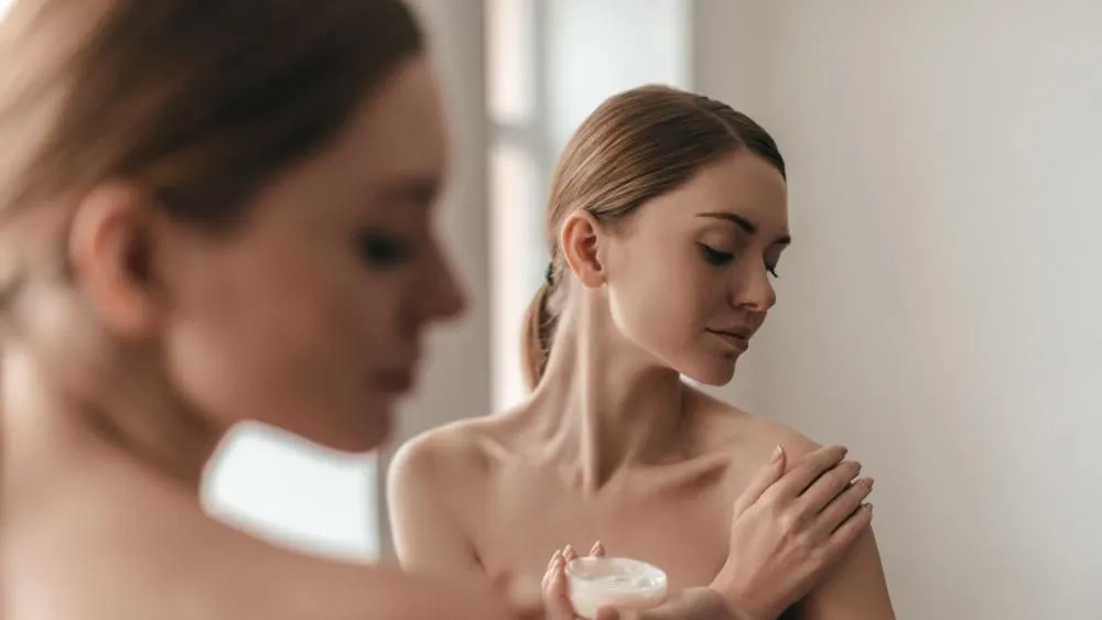 kobieta przygotowująca sk&oacute;rę do depilacji woskiem w domu