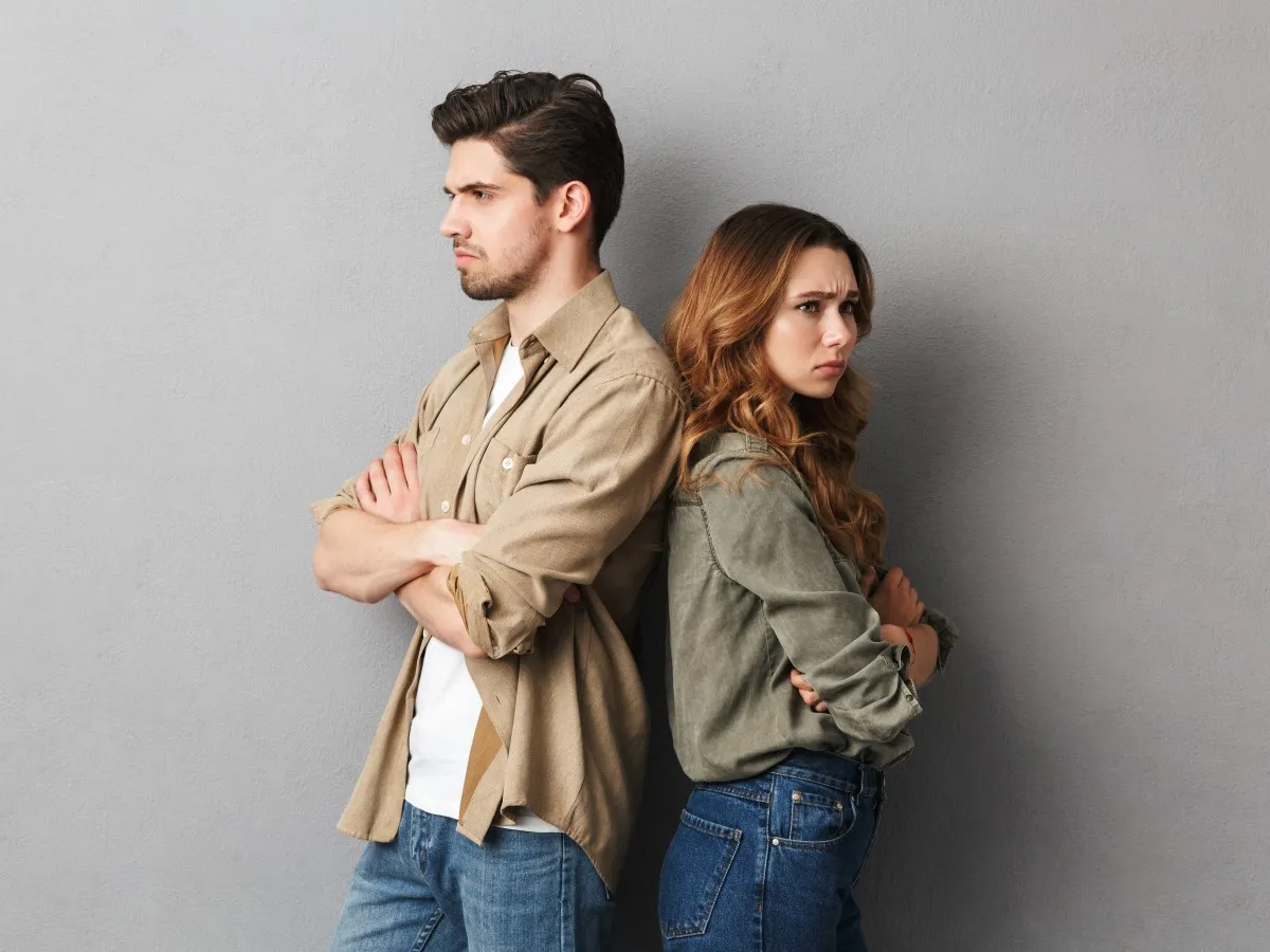 Para zwaśniona, stojąca plecami do siebie. On zamyślony, ona z wyrzutem. Jak przeprosić kobietę żeby wybaczyła?
