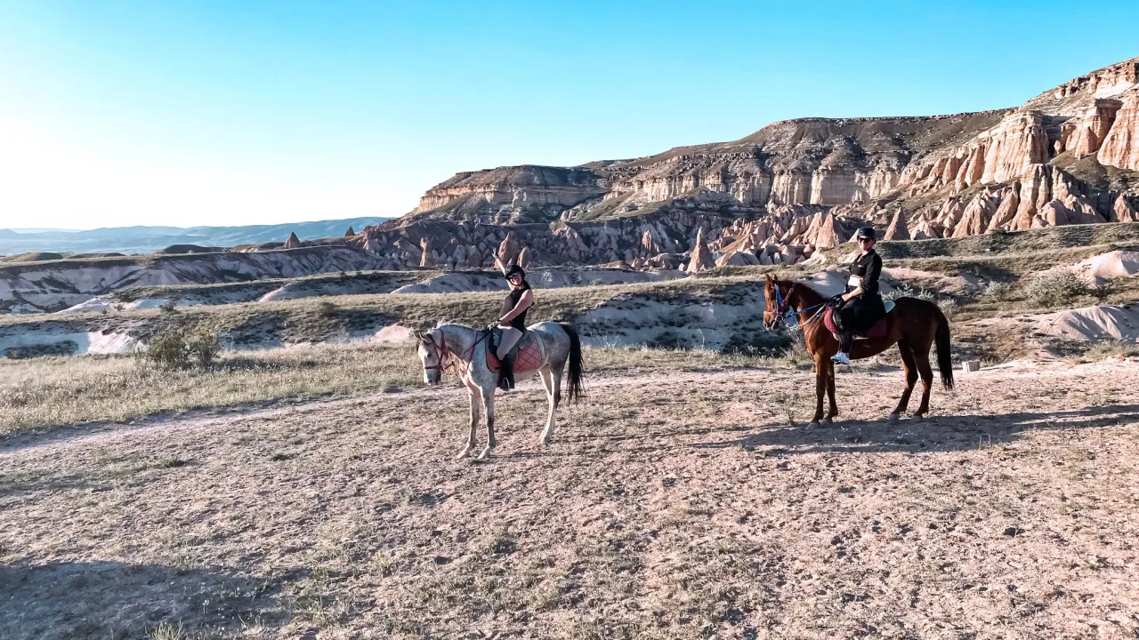 Dwie kobiety na koniach przemierzają pustynny krajobraz Kapadocji. To wspaniała przygoda, gdzie można poczuć się jak w filmie, a co to jest karosz? To właśnie taki wspaniały środek transportu!