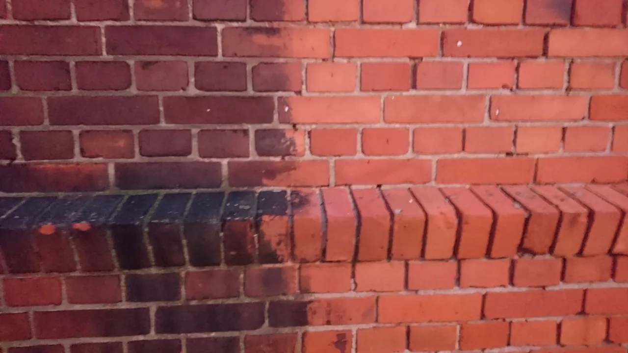 Ciemna, zabrudzona cegła po lewej kontrastuje z czystą, czerwoną po prawej. Pokazuje, jak czyścić cegłę, by przywrócić jej dawny blask.