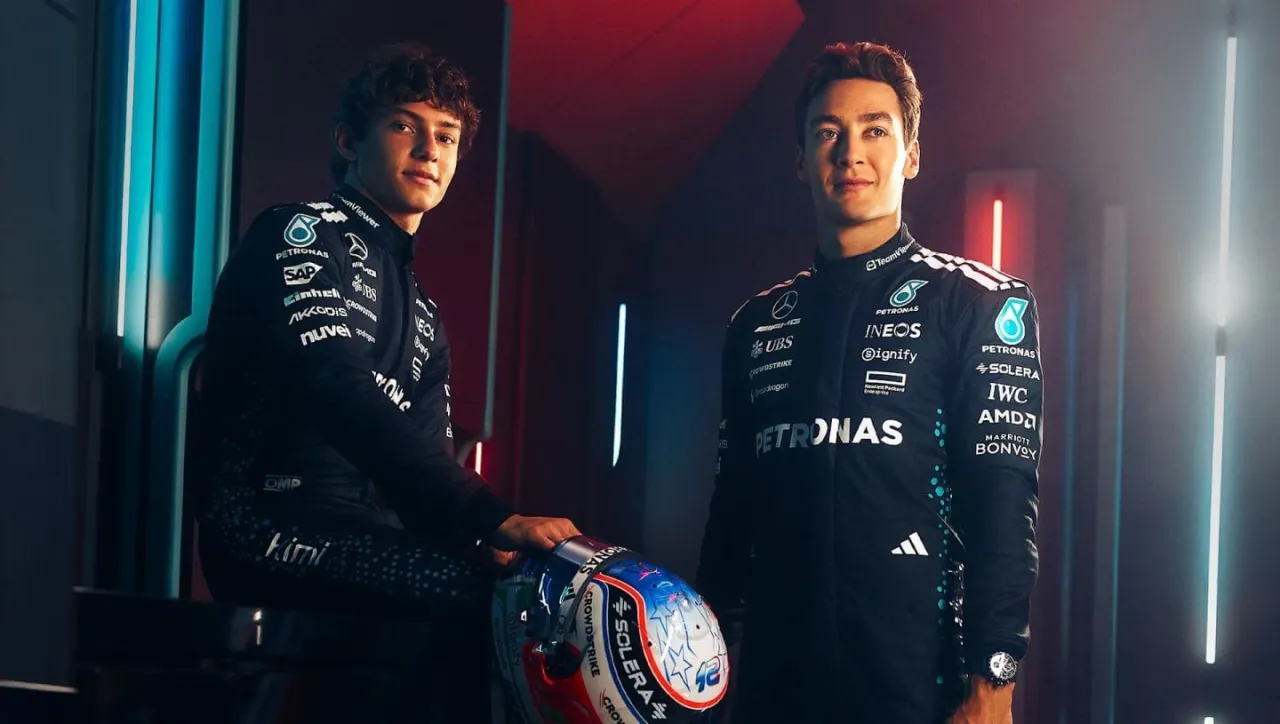 Dwóch kierowców zespołu Mercedes-AMG Petronas F1 w kombinezonach, jeden z kaskiem.